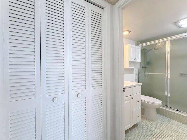 full bathroom featuring a closet, toilet, a stall shower, vanity, and tile patterned flooring