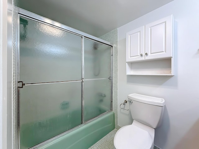 bathroom featuring bath / shower combo with glass door and toilet