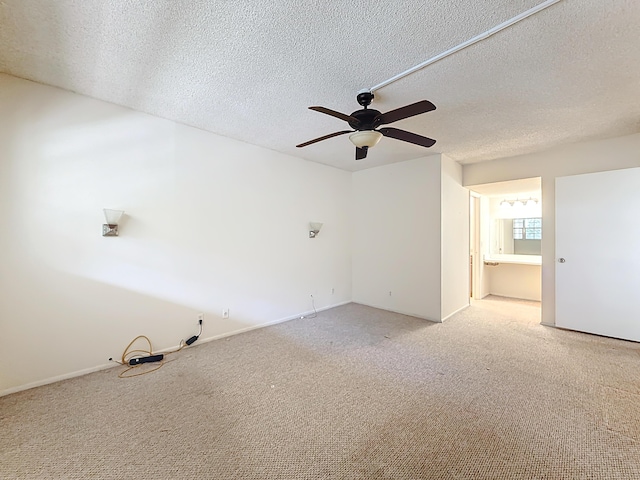 spare room with carpet floors, a ceiling fan, and a textured ceiling