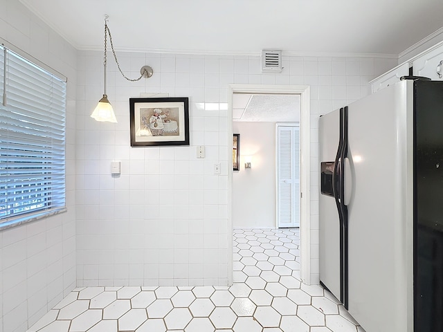 corridor with ornamental molding, visible vents, and tile walls