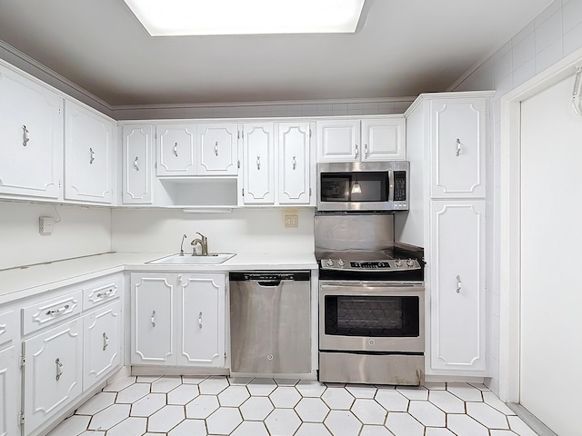 kitchen featuring stainless steel appliances, a sink, light countertops, and white cabinets