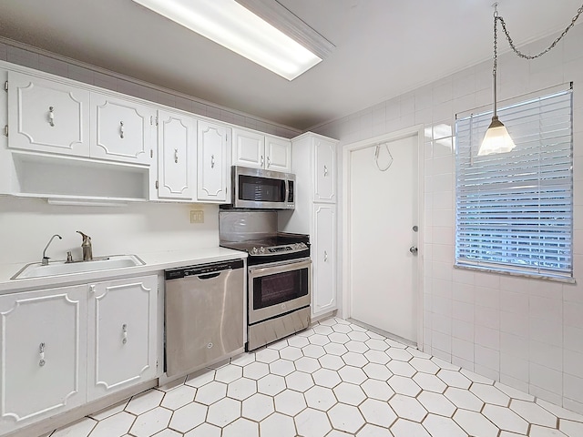 kitchen featuring open shelves, light countertops, hanging light fixtures, appliances with stainless steel finishes, and white cabinets