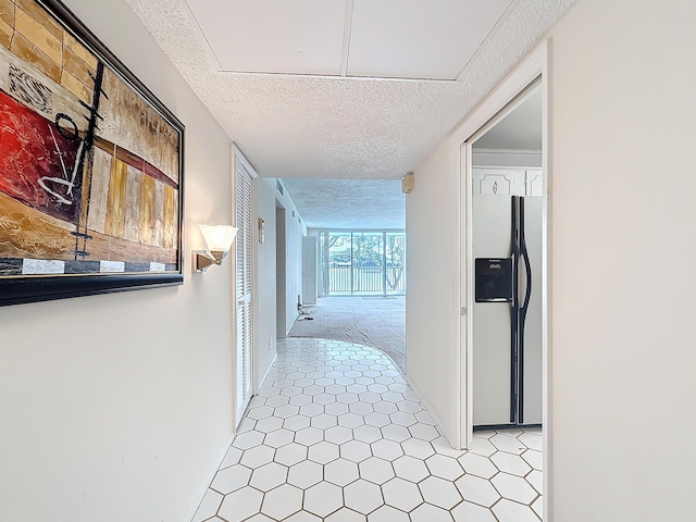 hall featuring a textured ceiling and light carpet