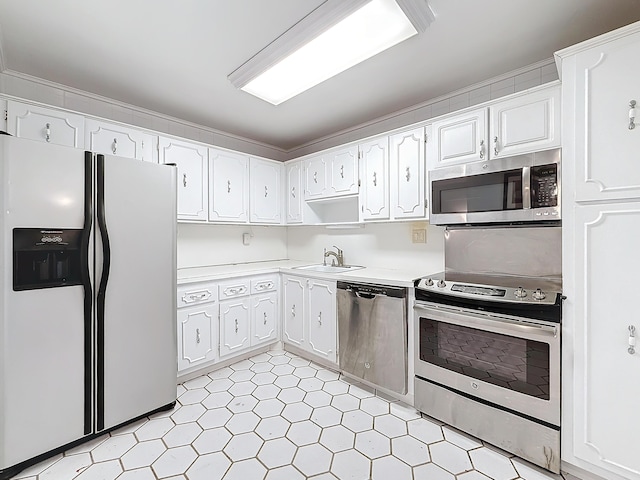 kitchen featuring stainless steel appliances, a sink, white cabinets, light countertops, and light floors