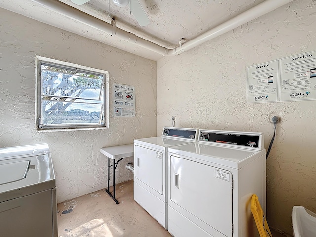 common laundry area with washer and clothes dryer and a textured wall