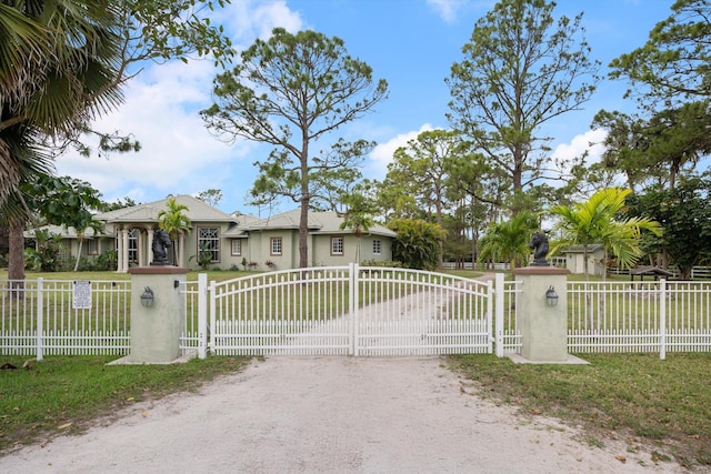 view of front of house featuring a fenced front yard, dirt driveway, and stucco siding