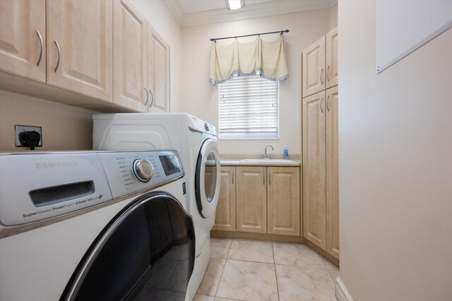 clothes washing area with cabinet space, crown molding, washer and clothes dryer, and a sink