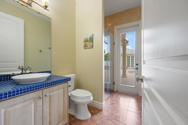 bathroom featuring toilet, tile patterned flooring, baseboards, and vanity