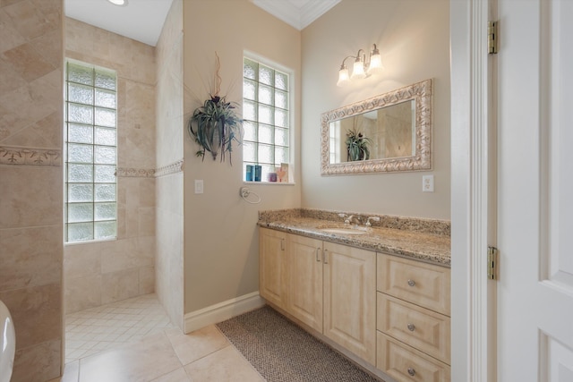 bathroom featuring a walk in shower, tile patterned flooring, vanity, baseboards, and ornamental molding