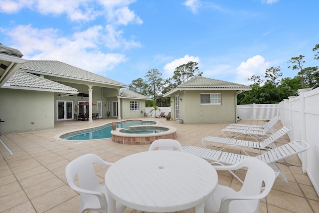 view of pool featuring a patio, a pool with connected hot tub, outdoor dining space, ceiling fan, and a fenced backyard