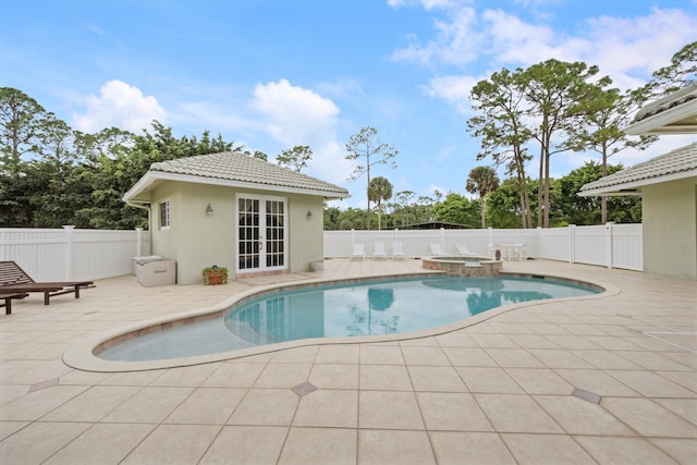 view of pool with an outbuilding, a patio, a fenced backyard, and a pool with connected hot tub