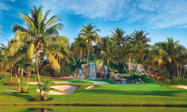 view of home's community with view of golf course and a yard