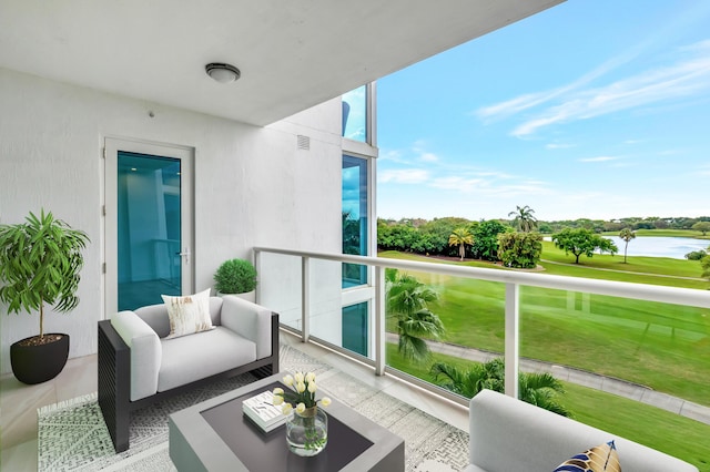 balcony with visible vents, a water view, and an outdoor living space