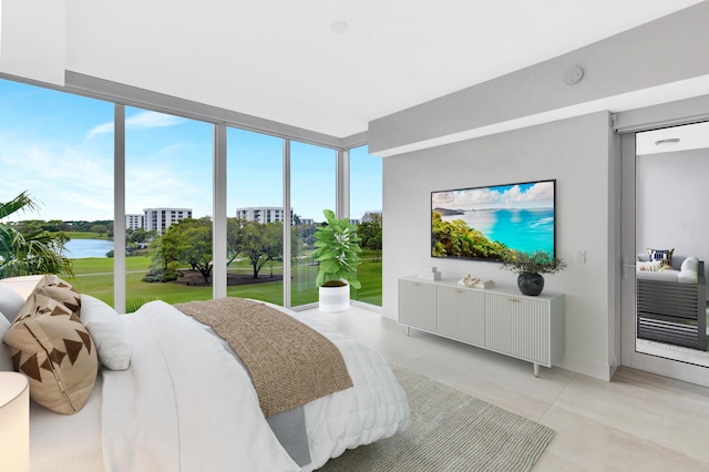 bedroom with a water view and a wall of windows