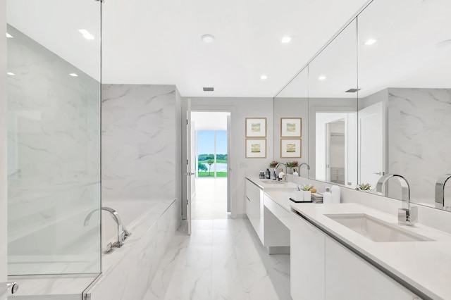 bathroom featuring marble finish floor, double vanity, recessed lighting, a sink, and a bath