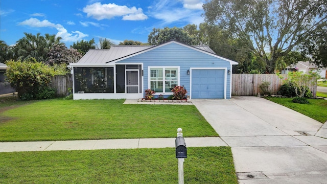 view of front of property featuring concrete driveway, a sunroom, an attached garage, fence, and a front yard