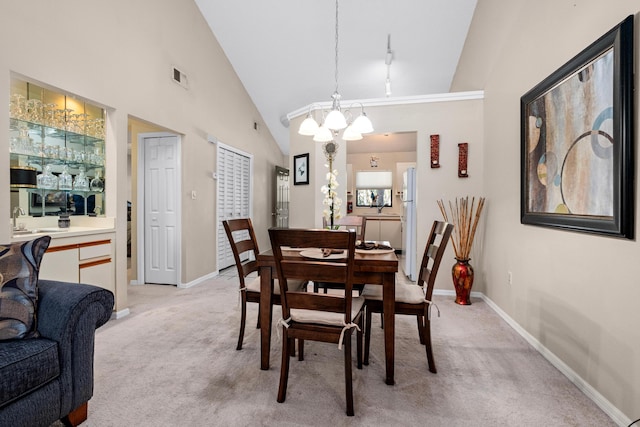 dining room with light carpet, baseboards, visible vents, and a notable chandelier