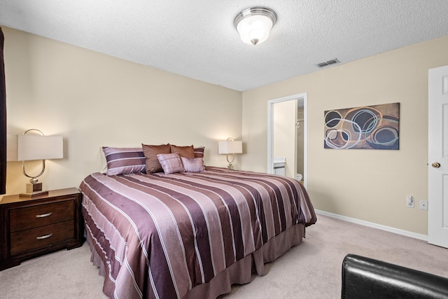 bedroom featuring light carpet, baseboards, visible vents, ensuite bathroom, and a textured ceiling