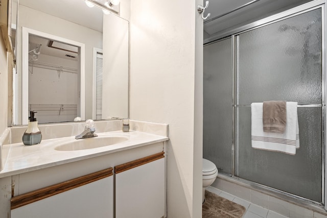 full bath featuring toilet, tile patterned flooring, a spacious closet, vanity, and a shower stall