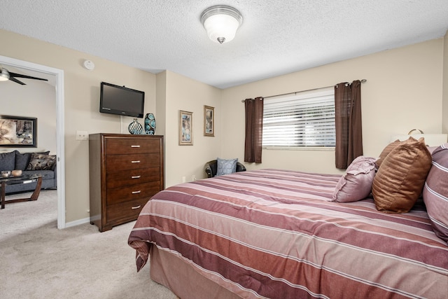 bedroom with light carpet, a textured ceiling, and baseboards