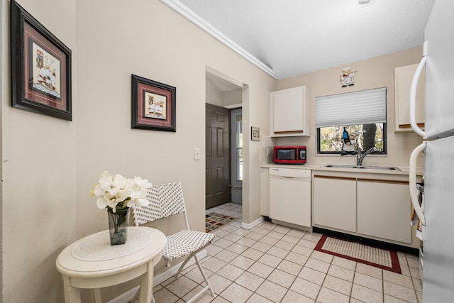 kitchen with light tile patterned flooring, white appliances, a sink, white cabinets, and light countertops