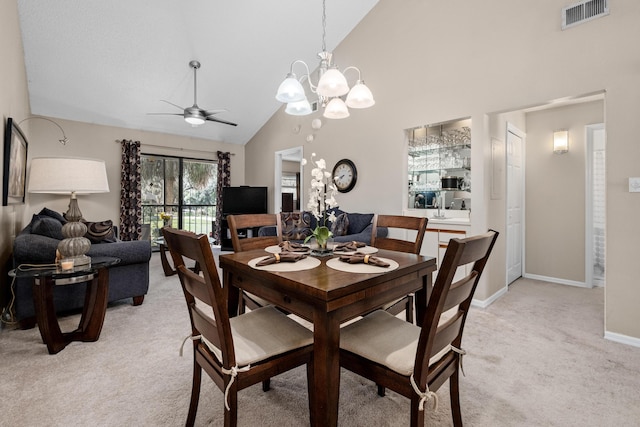 dining space featuring light carpet, baseboards, visible vents, high vaulted ceiling, and ceiling fan with notable chandelier