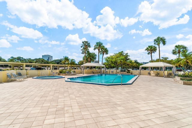 community pool with a gazebo, a patio, and a community hot tub