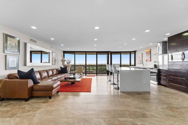 living room with expansive windows, visible vents, and recessed lighting