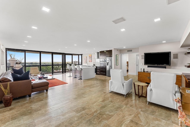 living room featuring expansive windows, visible vents, and recessed lighting