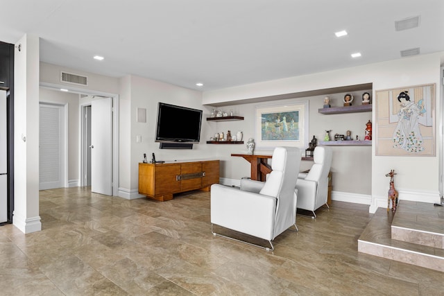 living area with recessed lighting, visible vents, and baseboards