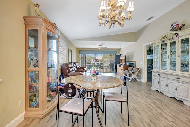 dining space featuring light wood finished floors, visible vents, vaulted ceiling, baseboards, and ceiling fan with notable chandelier