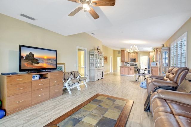 living room featuring light wood-style floors, visible vents, and ceiling fan with notable chandelier