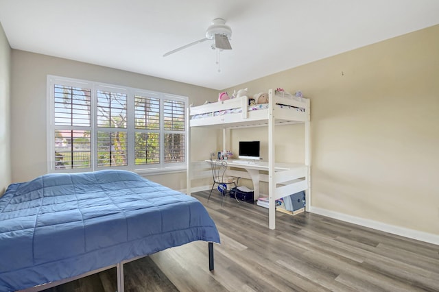 bedroom featuring a ceiling fan, baseboards, and wood finished floors