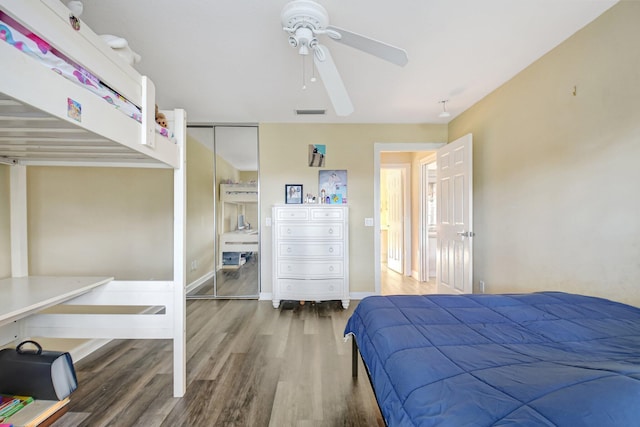 bedroom featuring a ceiling fan, visible vents, baseboards, and wood finished floors