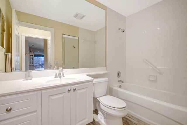 bathroom with visible vents, toilet, wood finished floors, vanity, and shower / bathing tub combination