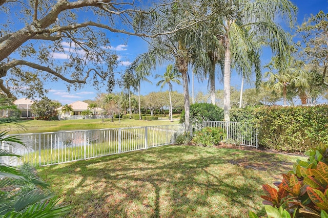 view of yard featuring a water view and a fenced backyard