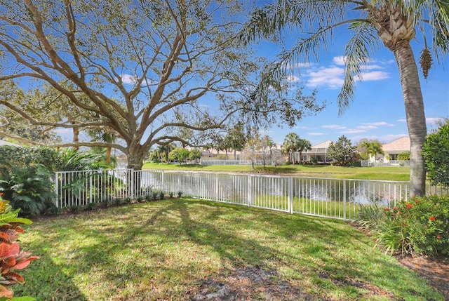 view of yard with a water view and a fenced backyard