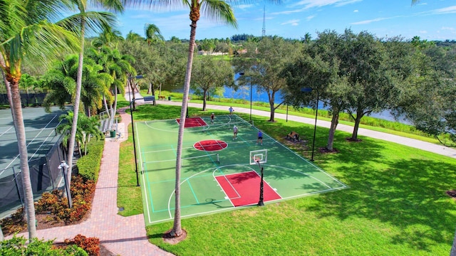 surrounding community with a water view, community basketball court, and a yard