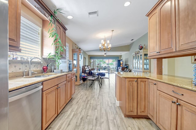 kitchen featuring decorative light fixtures, open floor plan, a sink, dishwasher, and a peninsula