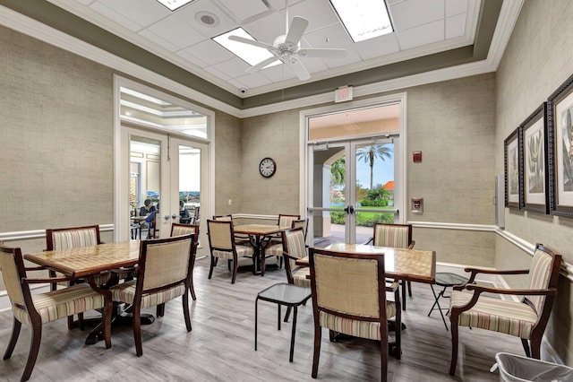 dining space with french doors, crown molding, and wood finished floors