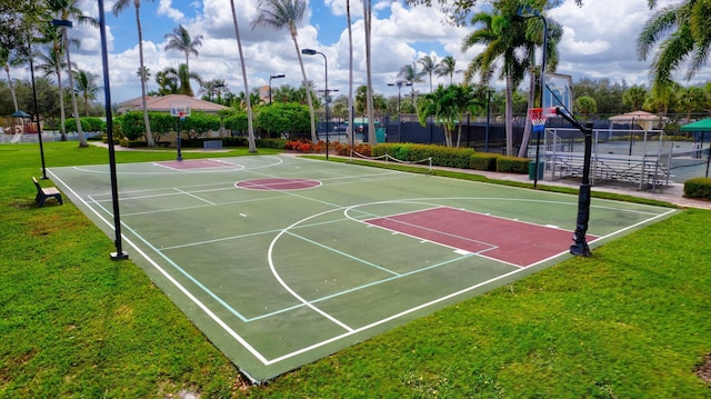 view of basketball court with community basketball court, a lawn, and fence