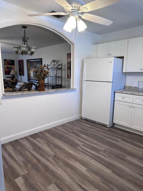 kitchen featuring freestanding refrigerator, white cabinets, and dark wood finished floors