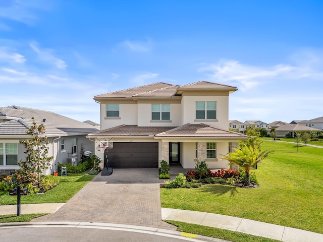 view of front facade with decorative driveway, a tile roof, stucco siding, an attached garage, and a front lawn