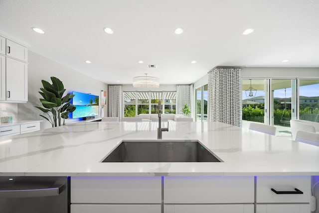 kitchen featuring visible vents, open floor plan, light stone countertops, white cabinetry, and recessed lighting