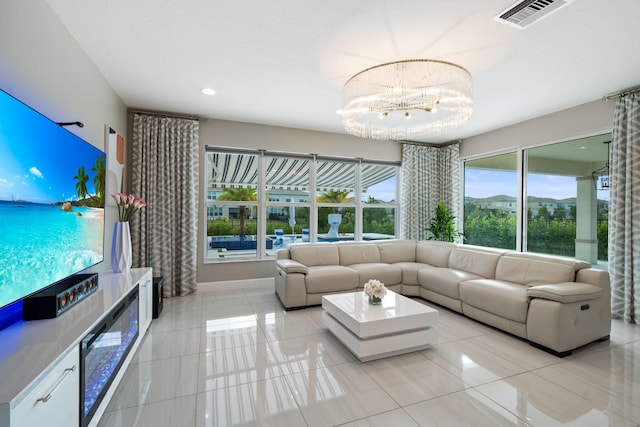 living area with a healthy amount of sunlight, an inviting chandelier, visible vents, and light tile patterned flooring