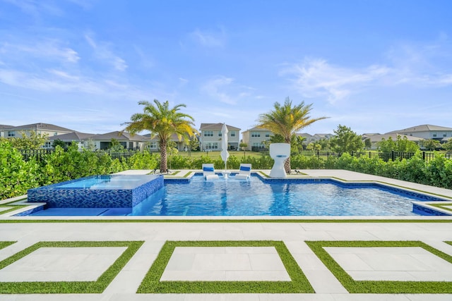 view of pool featuring a patio area, a pool with connected hot tub, a residential view, and fence