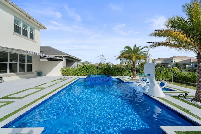 view of swimming pool with a patio area, fence, and a pool with connected hot tub