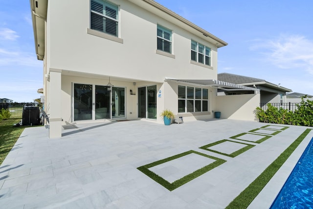 back of property featuring fence, a patio, and stucco siding