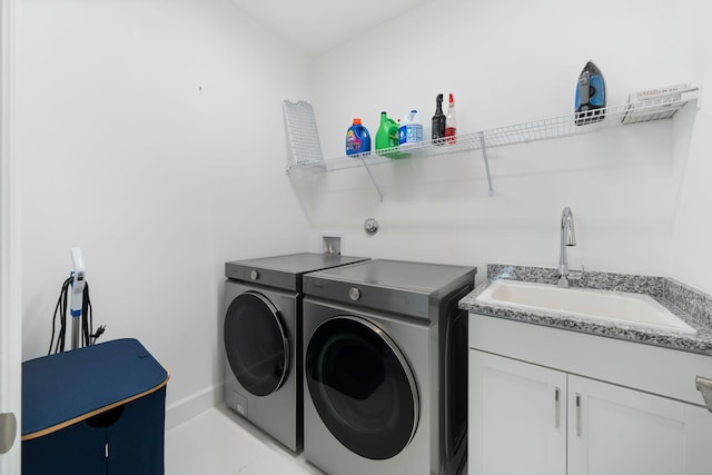 laundry room featuring baseboards, a sink, cabinet space, and washer and dryer