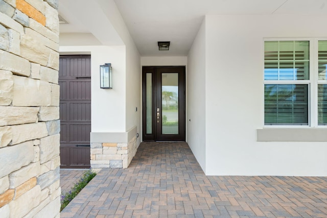 property entrance featuring stone siding and stucco siding